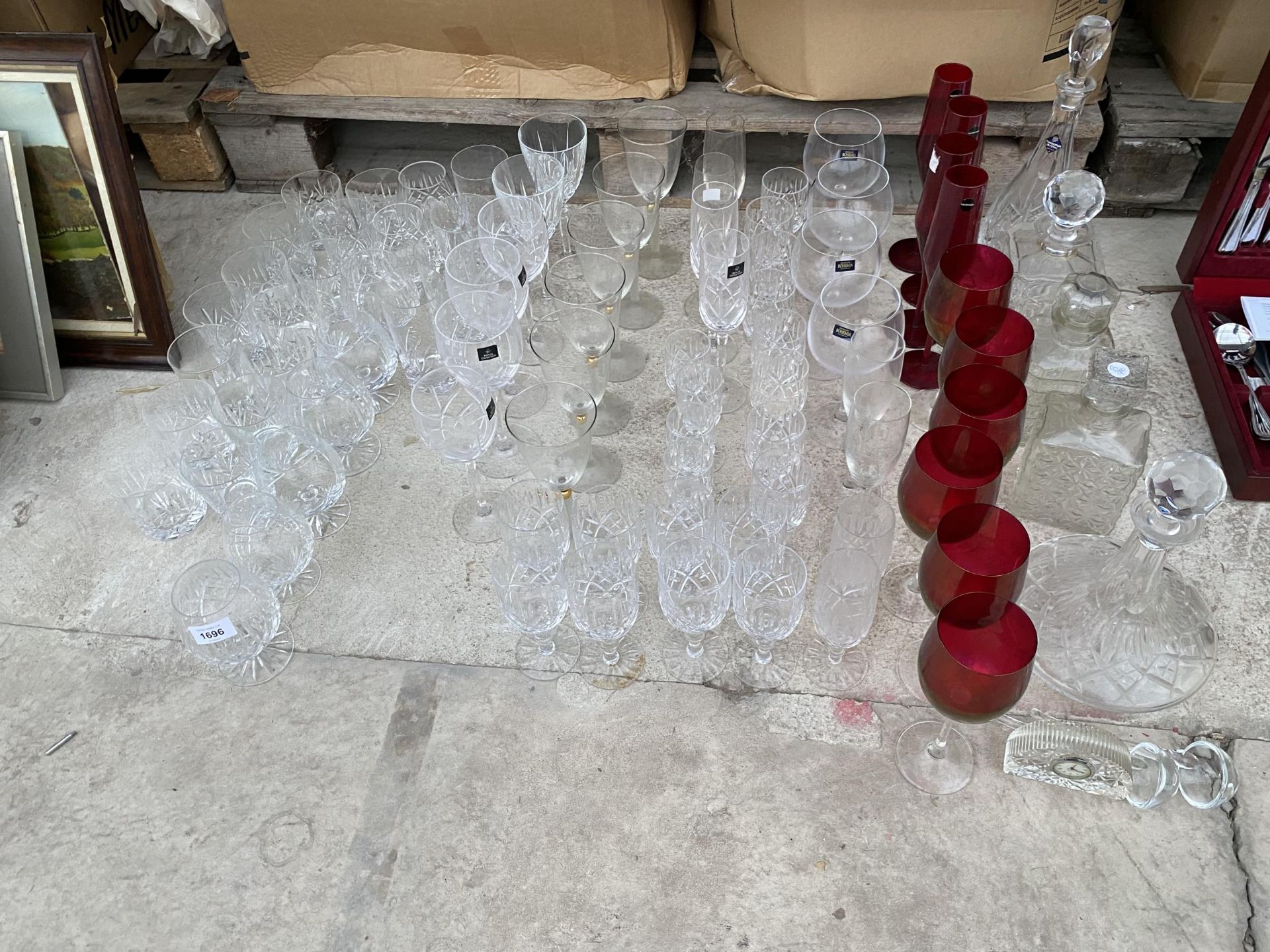 A LARGE ASSORTMENT OF MAINLY CRYSTAL GLASS WARE TO INCLUDE DECANTERS, WINE GLASSES AND CHAMPAGNE