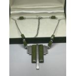AN ART DECO STYLE NECKLACE WITH GREEN STONES IN A PRESENTATION BOX