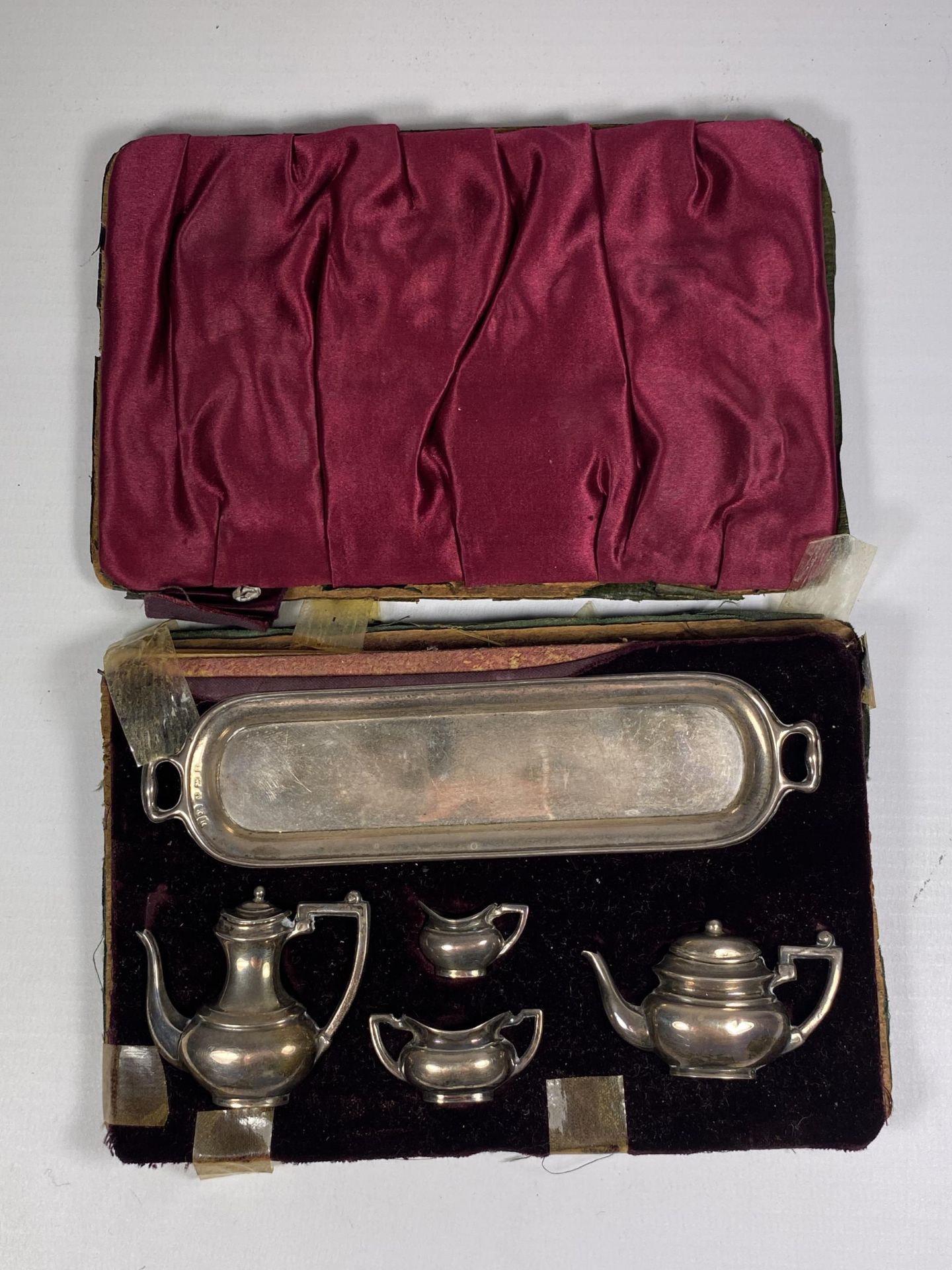 A MINIATURE 1920'S HALLMARKED SILVER TEA SET IN CASE (CASE A/F)