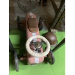 A VINTAGE PUSH ALONG RACING CAR WITH HELMET