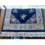 A BLUE PATTERNED FRINGED RUG