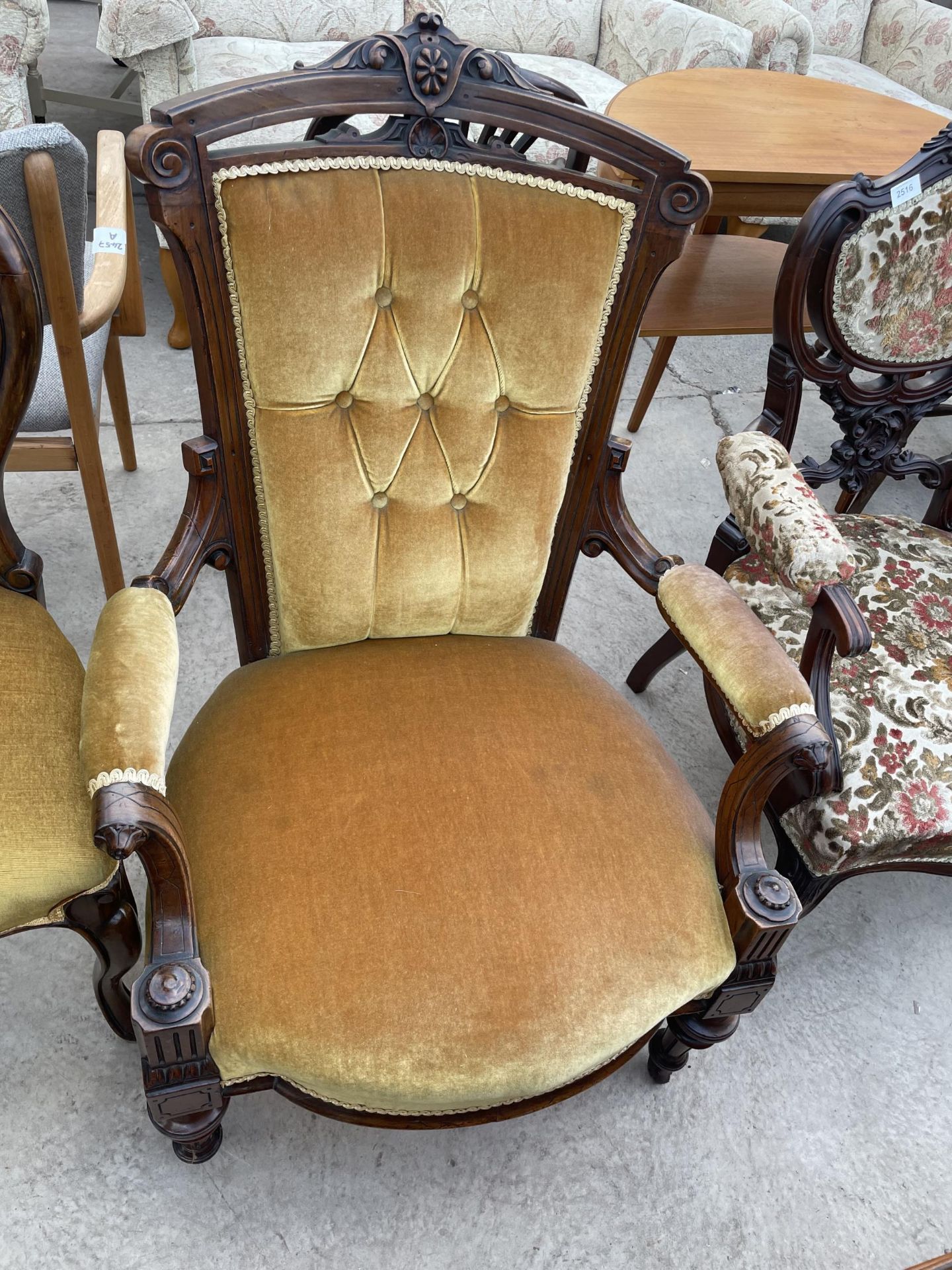 A VICTORIAN WALNUT FIRESIDE CHAIR ON TURNED AND FLUTED FRONT LEGS AND BUTTON BACKS