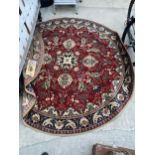 A RED PATTERNED OVAL RUG