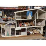 A DOLLS HOUSE WITH FURNITURE AND TWO DOLLS
