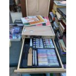 A WOODEN ARTIST BOX WITH, SCETCH PADS, CANVAS', PASTELS AND PENCILS ETC