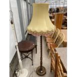 AN EARLY 20TH CENTURY OAK BARLEYTWIST STANDARD LAMP COMPLETE WITH SHADE