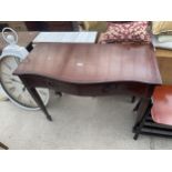 A REPRODUCTION MAHOGANY AND CROSSBANDED SERPENTINE FRONTED SIDE TABLE WITH TWO DRAWERS ON TAPERING