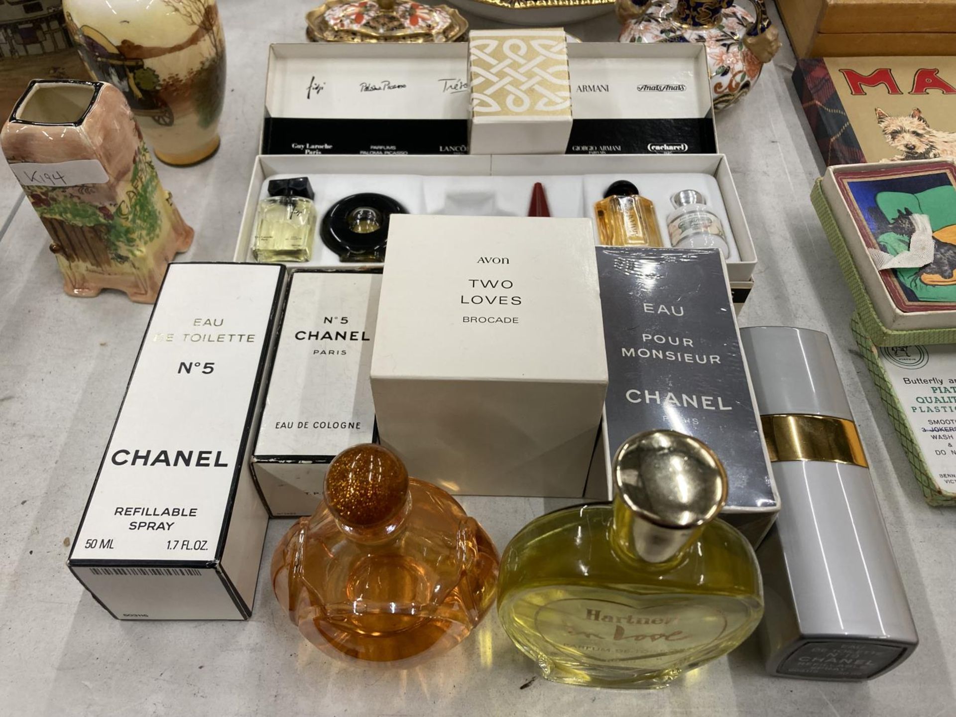 A COLLECTION OF PART BOTTLES OF EAU DE COLOGNES TO INCLUDE CHANEL NO 5, AVON, A BOXED MINIATURES