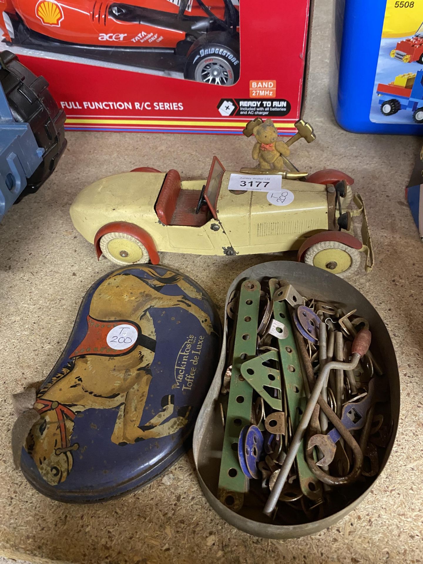 A VINTAGE TIN PLATE MECCANO RACING CAR MODEL AND TIN OF SPARE PARTS