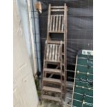 A VINTAGE WOODEN SIX RUNG STEP LADDER AND A FOUR RUNG WOODEN STEP LADDER