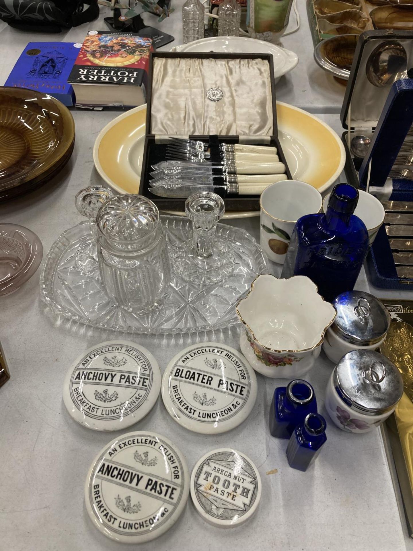 A QUANTITY OF ITEMS TO INCLUDE POT LIDS, BOXED FLATWARE, VINTAGE BLUE BOTTLES, GLASS DRESSISNG TABLE