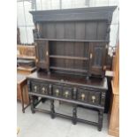 AN OAK JACOBEAN STYLE DRESSER WITH PLATE RACK ENCLOSING CUPBOARDS, THREE CARVED DRAWERS TO BASE ON