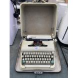 A RETRO OLYMPIA TYPEWRITER WITH CARRY CASE