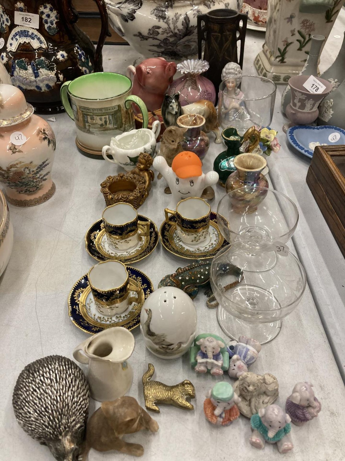 A MIXED LOT TO INCLUDE SMALL CUPS AND SAUCERS, ANIMAL FIGURES, GLASSWARE, A DOULTON MUG, ETC