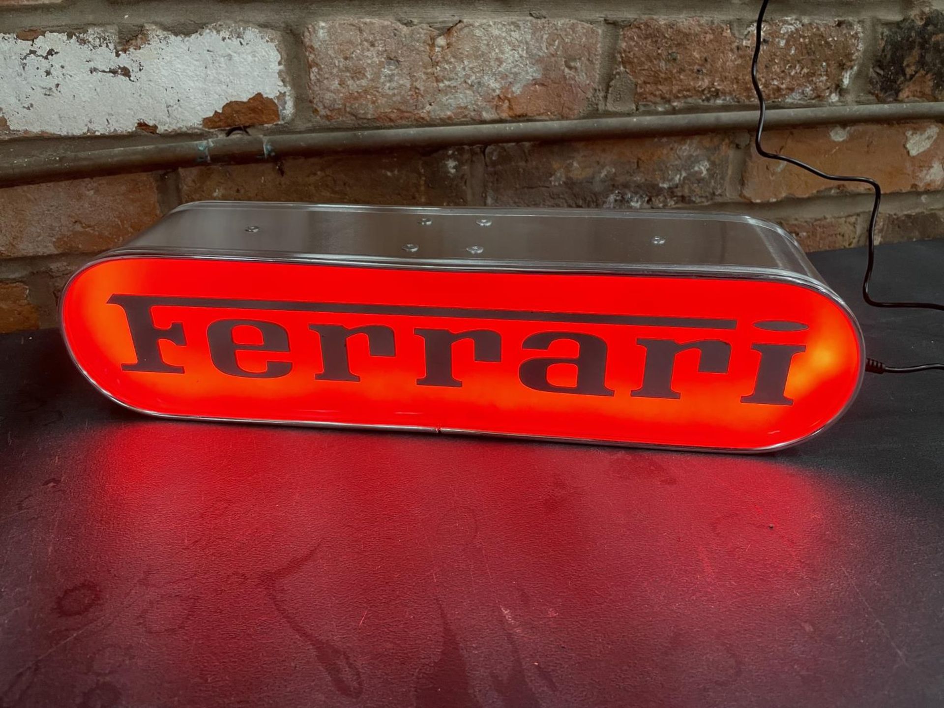 A FERRARI ILLUMINATED LIGHT BOX SIGN - WORKING ORDER AT TIME OF CATALOGUING. WIDTH 44CM, HEIGHT 10.