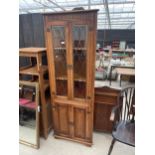 AN OAK OLD CHARM STYLE TWO DOOR GLAZED CORNER CABINET WITH TWO LINENFOLD DOORS TO BASE, 26" WIDE