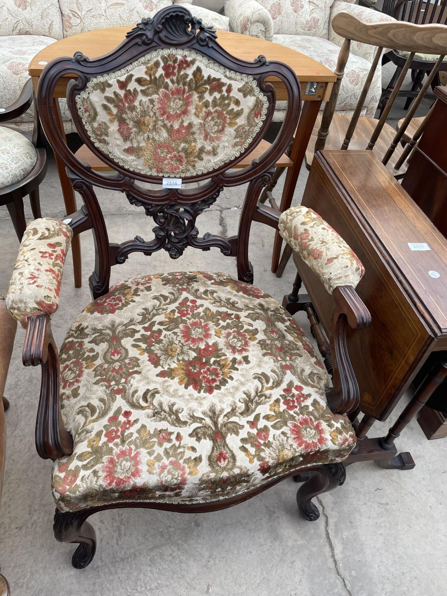 A VICTORIAN MAHOGANY OPEN ARMCHAIR ON CABRIIOLE LEGS WITH CARVED FOLIATE BACK