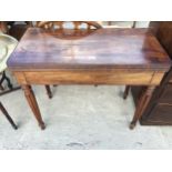 A 19TH CENTURY MAHOGANY FOLD OVER GAMES TABLE ON TURNED AND FLUTED LEGS, 34" WIDE