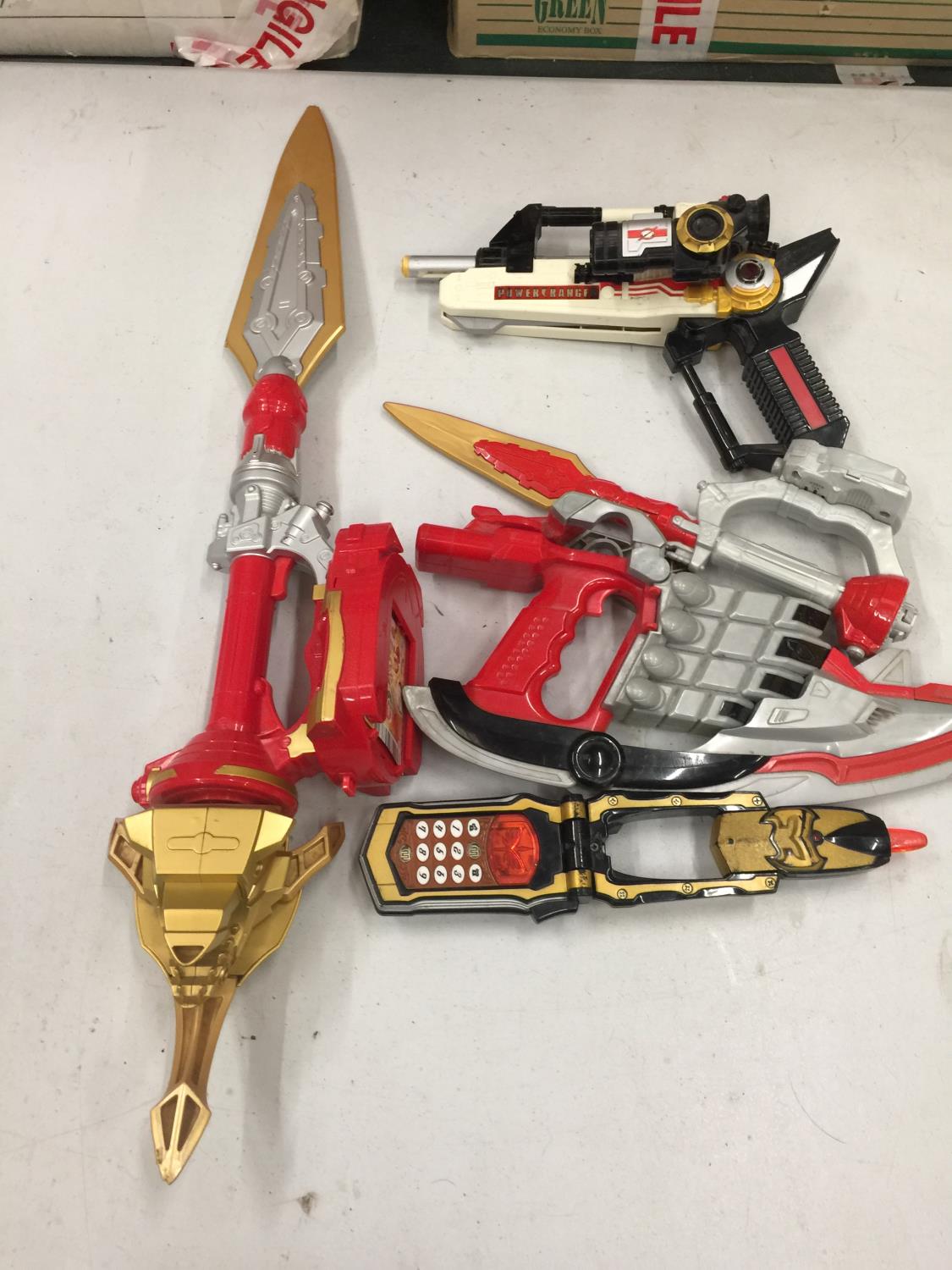 A QUANTITY OF POWER RANGER WEAPONS AND ACCESSORIES TO INCLUDE A PHONE, GUN, SWORDS, ETC