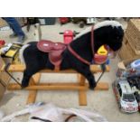 A PLUSH CHILDS ROCKING HORSE WITH WOODEN BASE