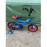 A CHILDRENS BIKE WITH STABILISERS AND MONSTER TRUCK DETAIL