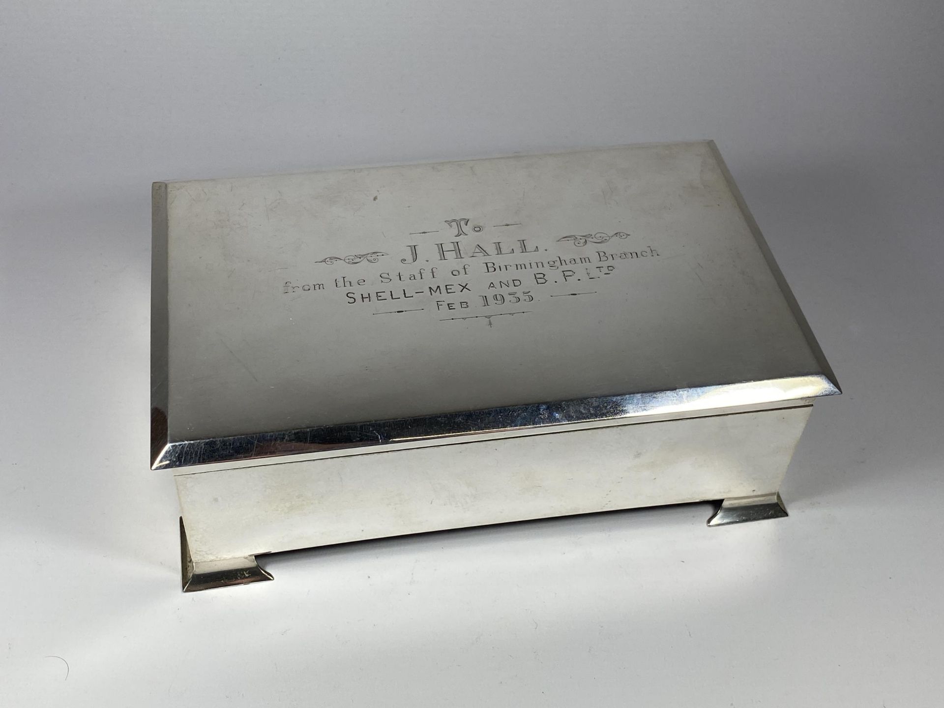 AN ART DECO 1930'S HALLMARKED BIRMINGHAM SILVER OVER-SIZED CIGARETTE BOX WITH SHELL-MEX & B.P