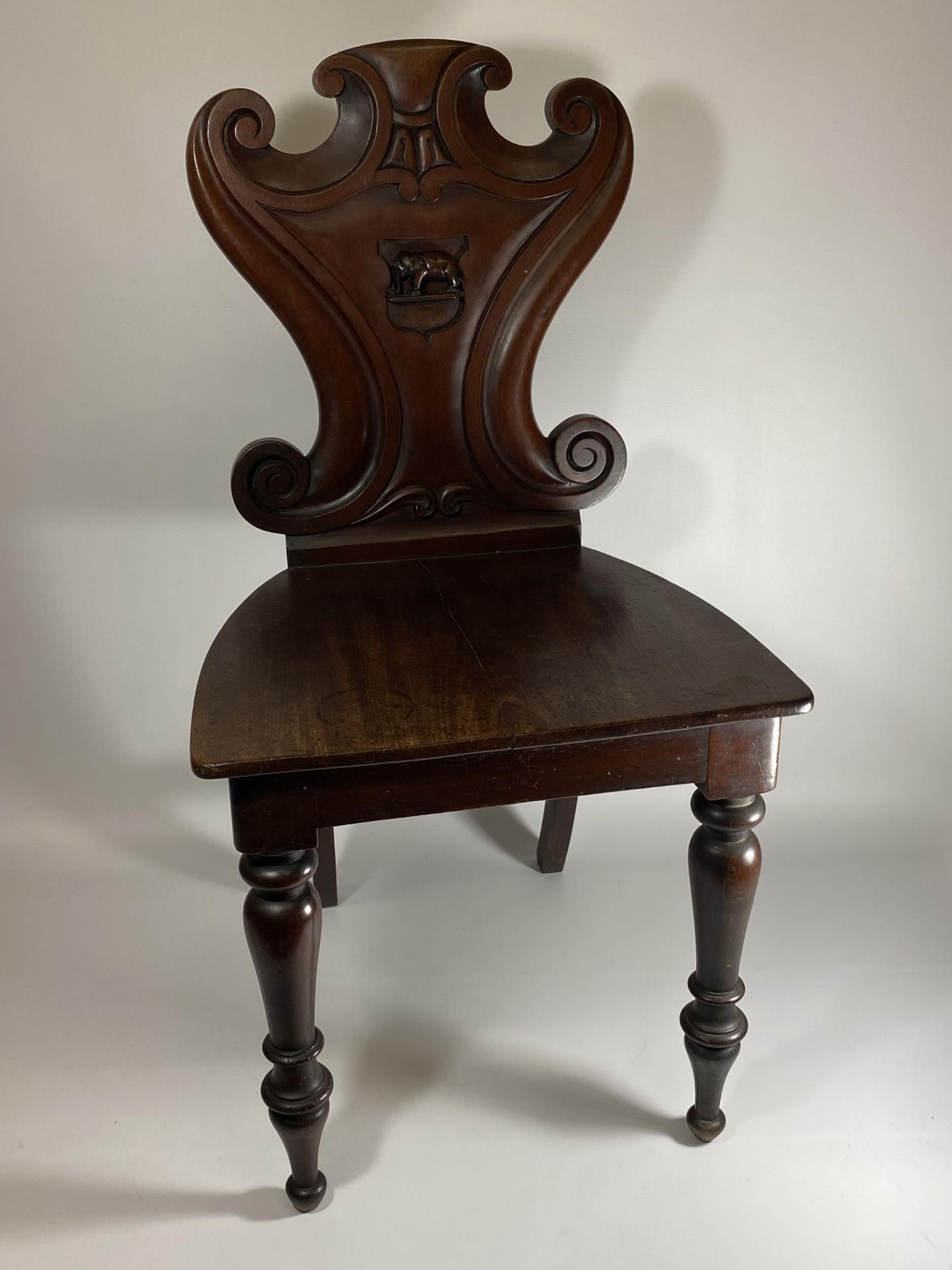 A 19TH CENTURY MAHOGANY CARVED BEDROOM CHAIR WITH ELEPHANT DESIGN BACK