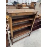 AN OAK THREE TIER BOOKCASE ON BARLEY TWIST SUPPORTS WITH STRETCHER RAILS