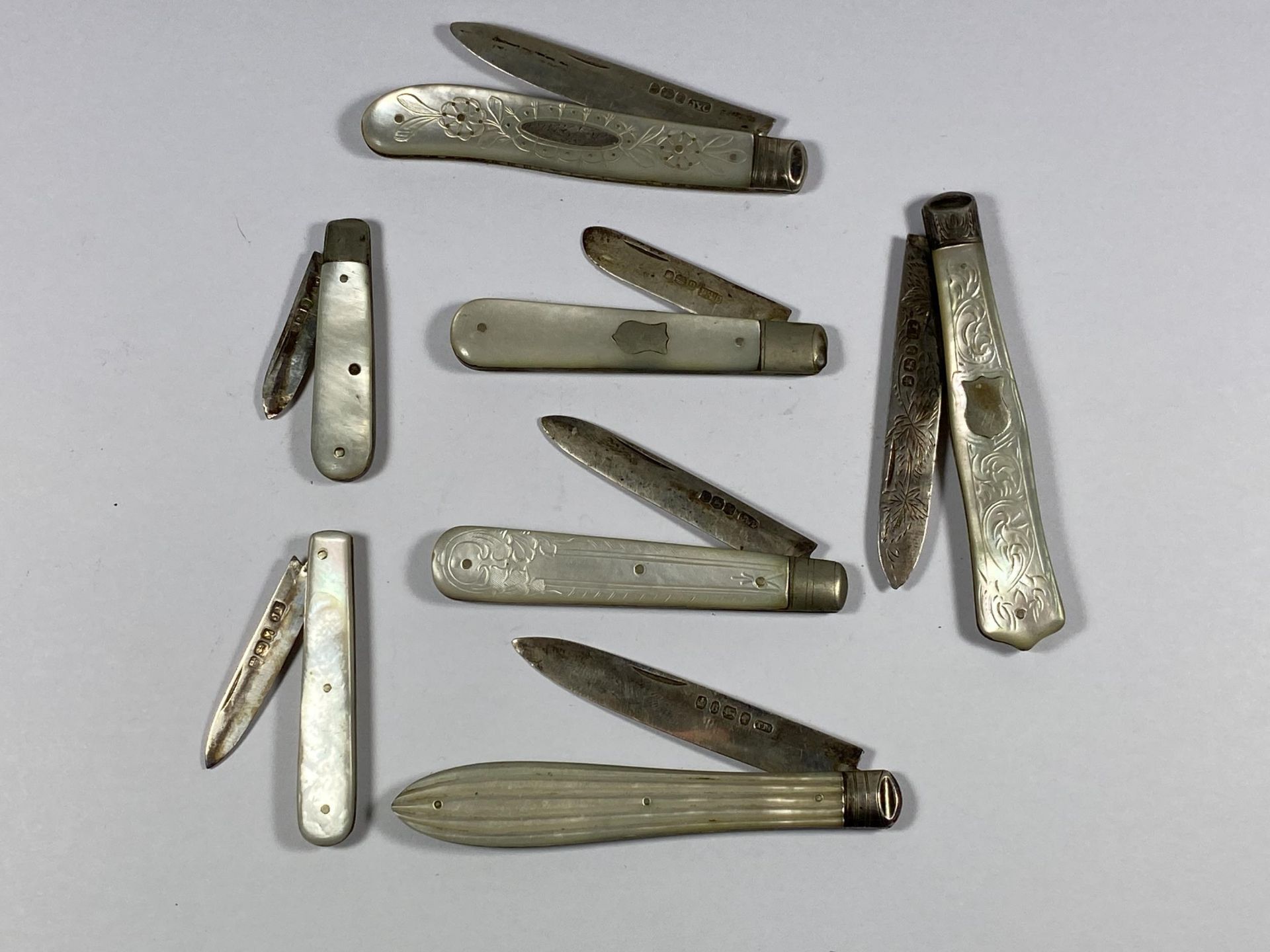 A SET OF SEVEN HALLMARKED SILVER AND MOTHER OF PEARL FRUIT KNIVES