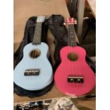 A PINK AND A BLUE CHILD'S UKELELE IN BAGS