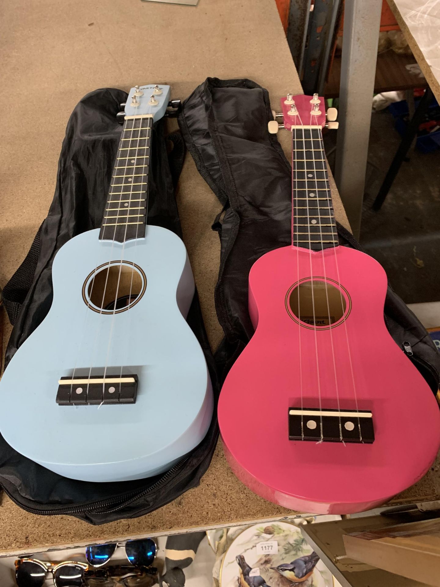 A PINK AND A BLUE CHILD'S UKELELE IN BAGS