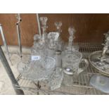 AN ASSORTMENT OF GLASS ITEMS TO INCLUDE DECANTORS, JUGS AND A BASKET ETC