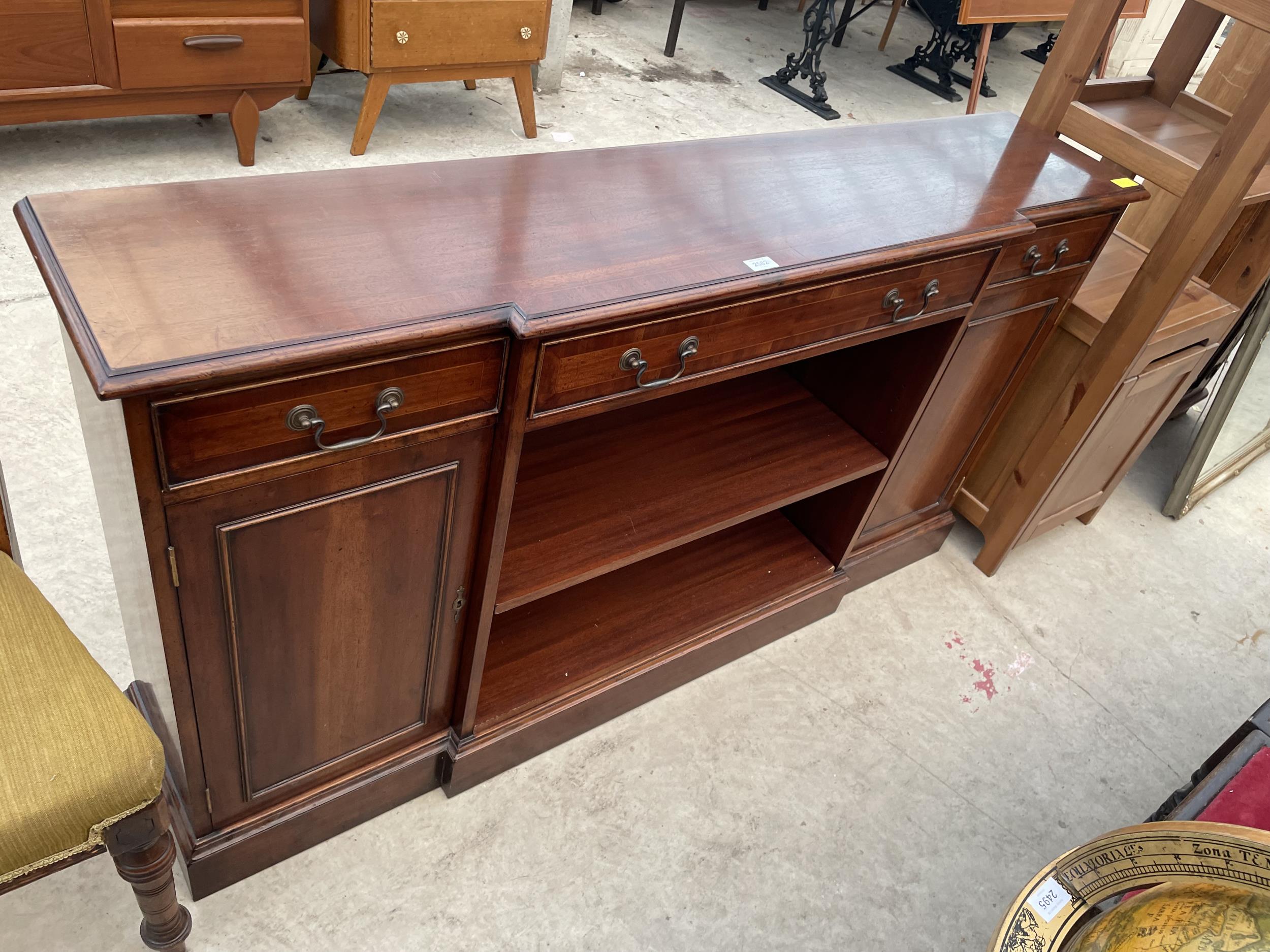 A REPRODUCTION MAHOGANY AND CROSSBANDED BREAKFRONT BOOKCASE WITH TWO CUPBOARDS AND THREE DRAWERS,