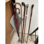 FOUR VARIOUS WALKING STICKS, ONE WITH A HALLMARKED SILVER HANDLE, A STICK SEAT AND AN UMBRELLA