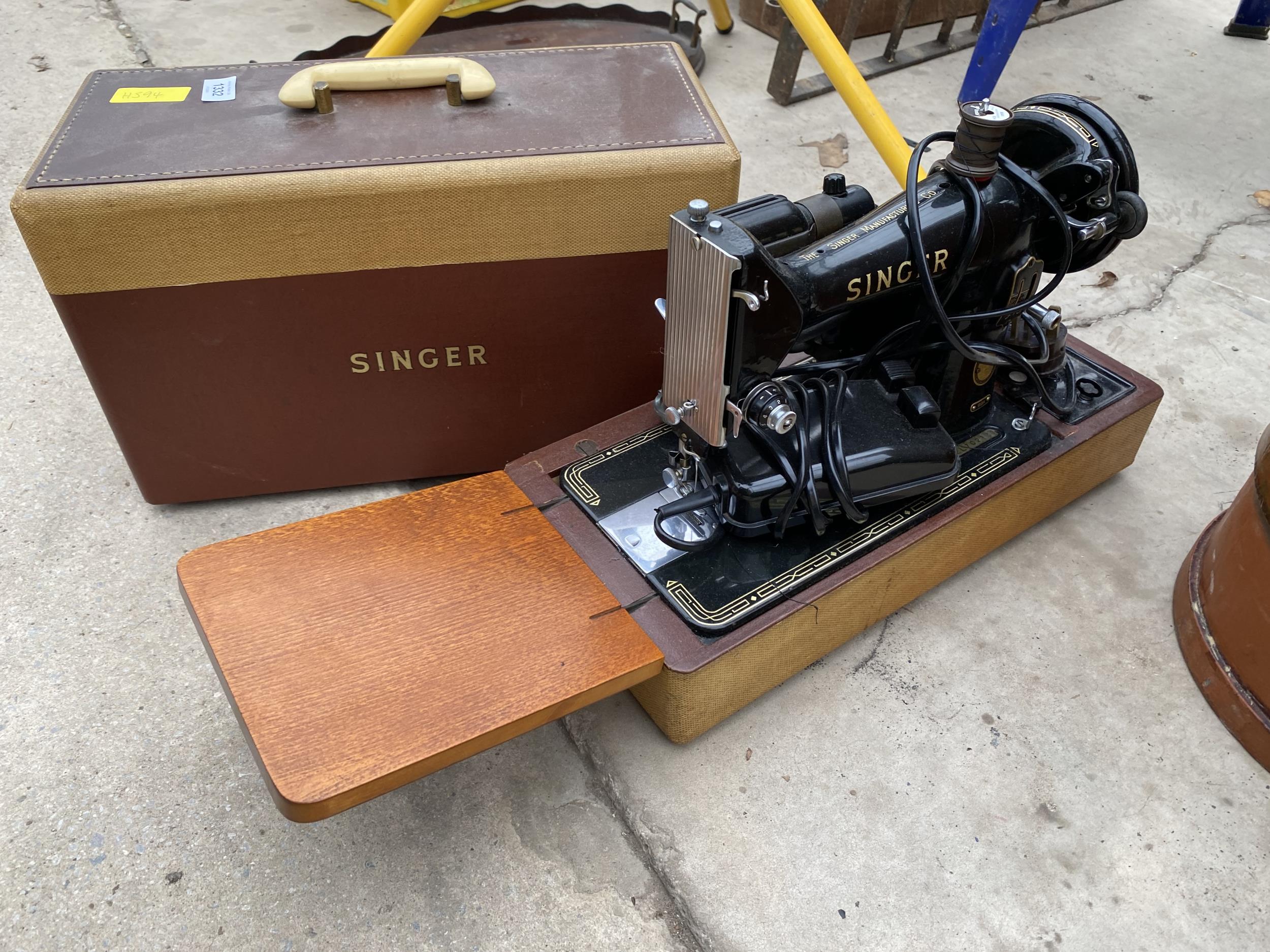 AN ELECTRIC SINGER SEWING MACHINE WITH FOOT PEDAL AND CARRY CASE