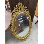 A MODERN OVAL GILT FRAMED WALL MIRROR, 29X18"