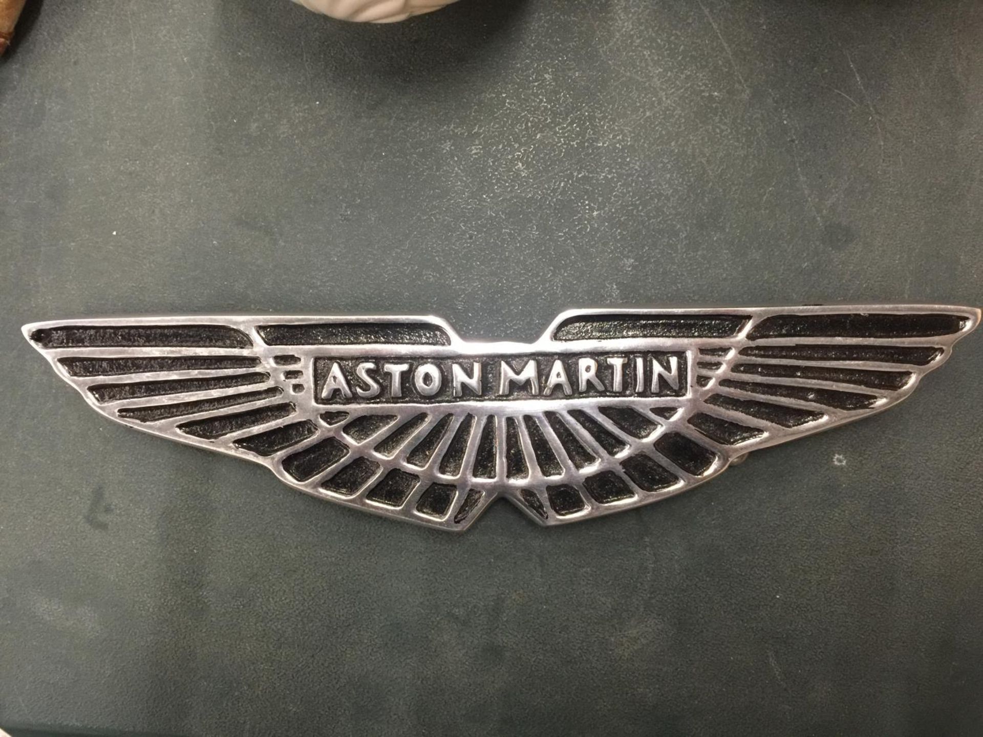 A CHROME ASTON MARTIN SIGN