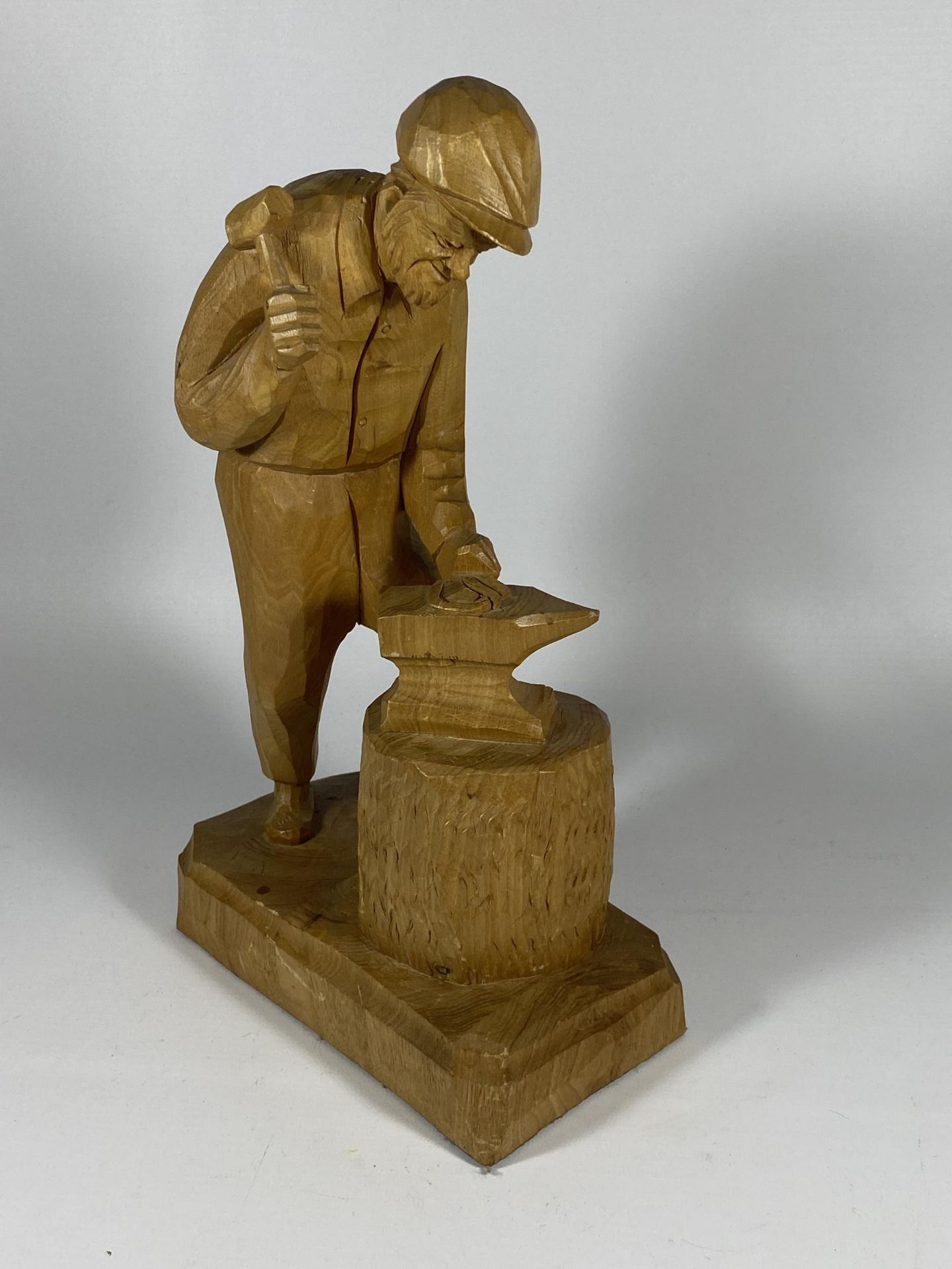 A CARVED WOODEN MODEL OF A BLACKSMITH