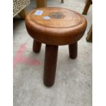 A SMALL MAHOGANY STOOL, 8" DIAMETER, WITH OLD PENNY INSET TO THE TOP