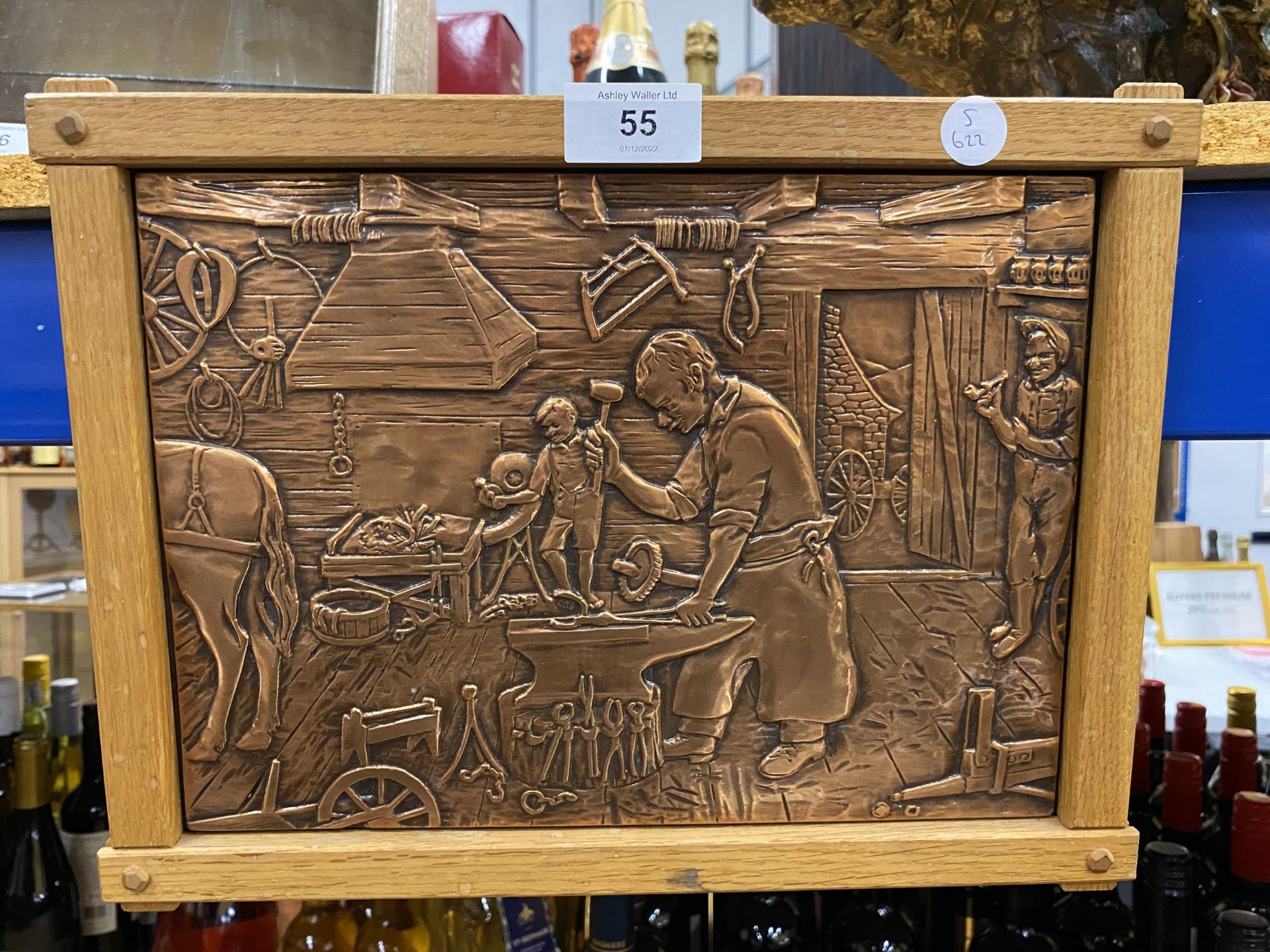 A WOODEN FRAMED COPPER PLAQUE OF A BLACKSMITH