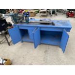 A NAEROK LTD. WOOD LATHE FIXED TO A WOODEN WORK BENCH ENCLOSING TWO LOWER CUPBOARDS AND FOUR