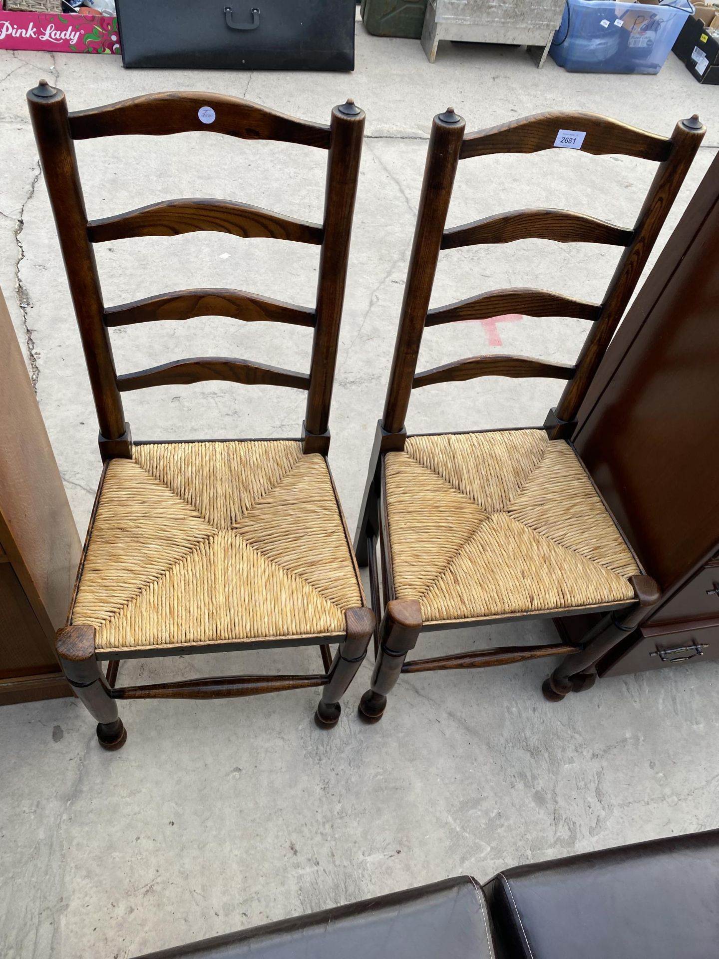 A PAIR OF ELM AND BEECH LADDERBACK DINING CHAIRS WITH RUSH SEATS