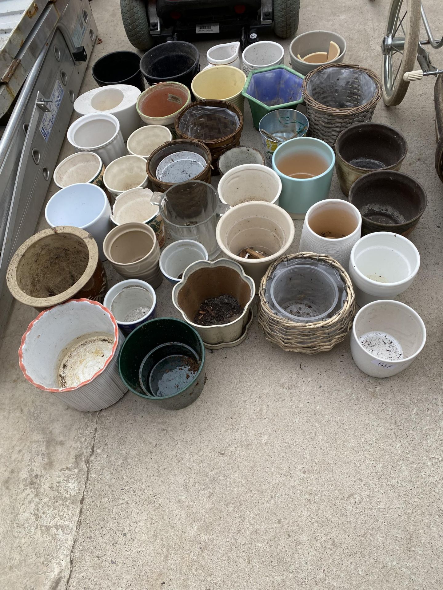 A LARGE QUANTITY OF CERAMIC AND WICKER PLANT POTS