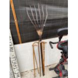 AN ASSORTMENT OF FIVE WALKING STICKS AND A VINTAGE WOODEN RAKE