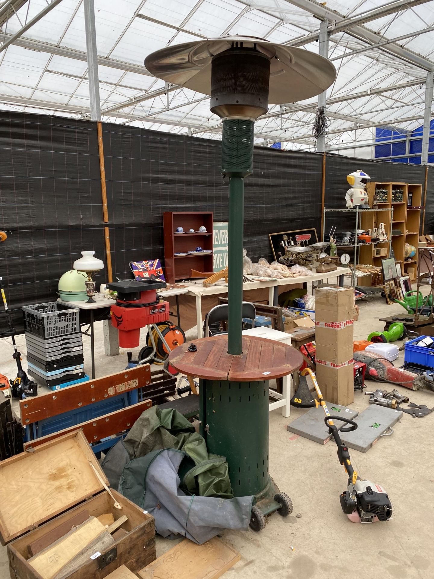 A LARGE GAS PATIO HEATER WITH TEAK EFFECT TABLE SURROUND AND COVER