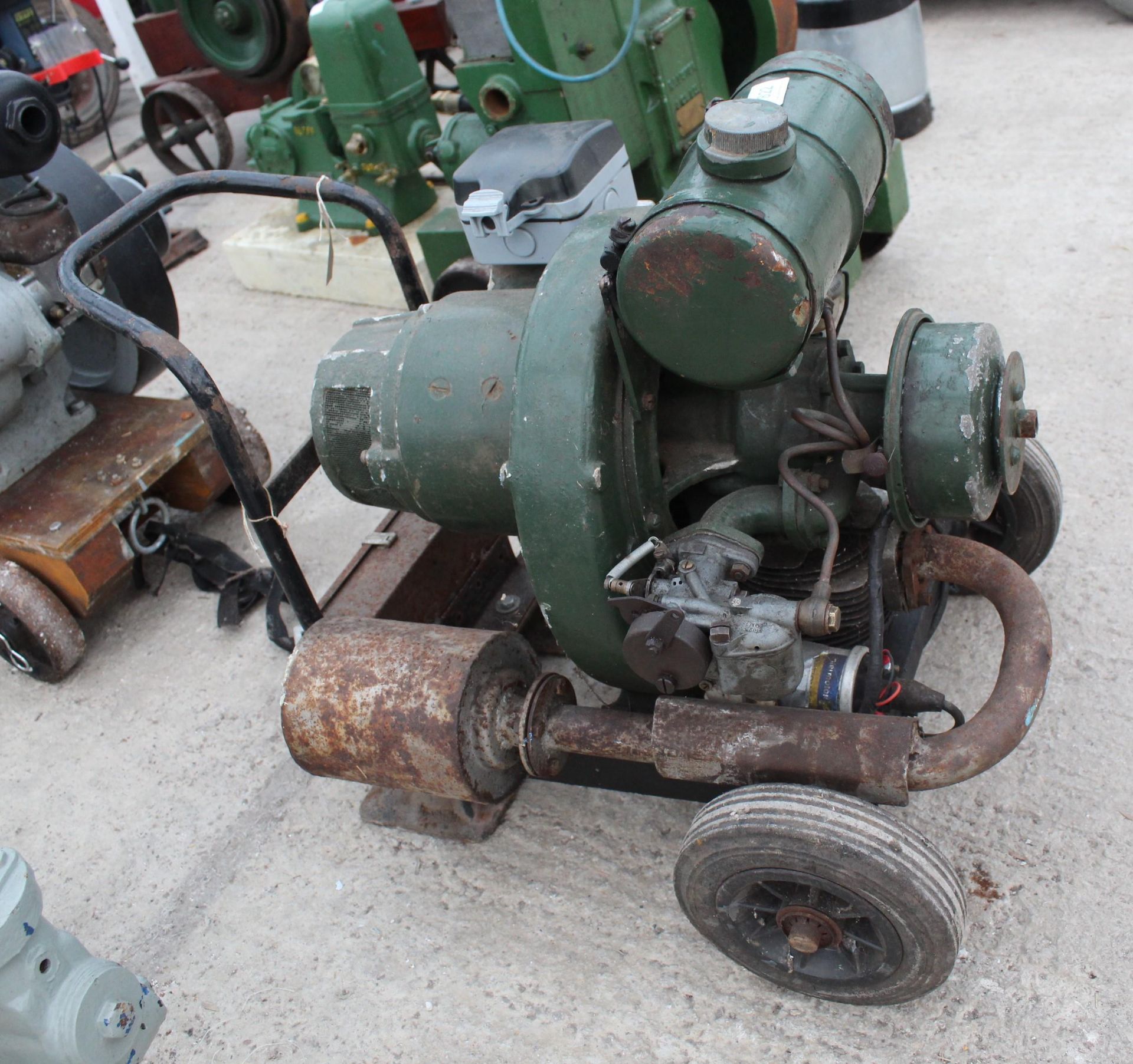 A VINTAGE HOMELITE PETROL GENERATOR ON A FOUR WHEELED TROLLEY BASE (MODERN ELECTRICAL ADDITIONS)