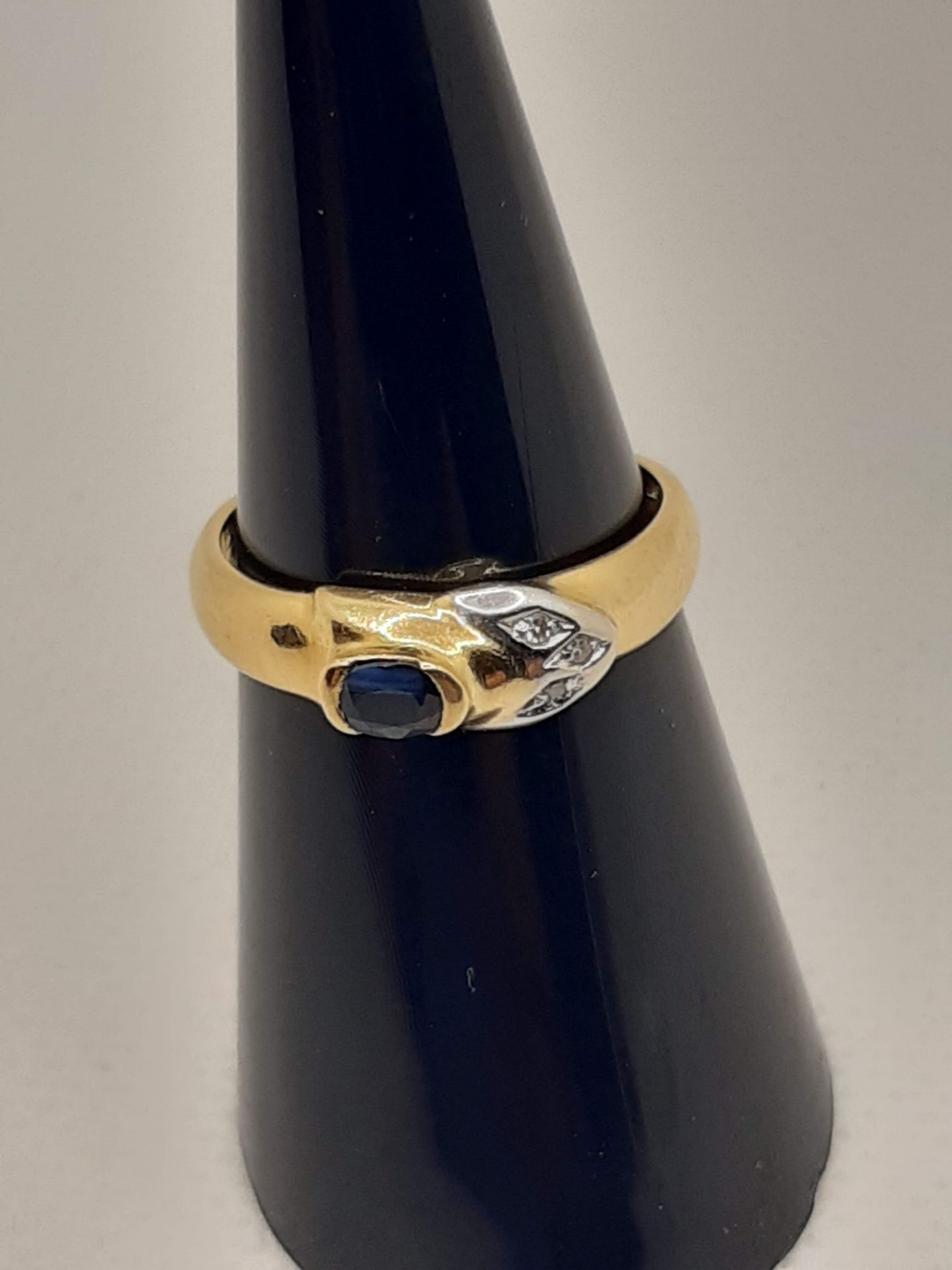 18 CARAT YELLOW GOLD RING WITH 3 LIGHT STITCH AND OVAL -CUT CENTRAL SAPPHIRE - MEASURES 12 - 3.1