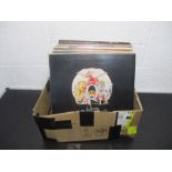A collection of 12" vinyl records including Queen, Rod Stewart, Jethro Tull, Wings, Santana, Phil