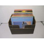 A collection of 12" vinyl records including Dire Straits, John Lennon, Styx, Carly Simon, Phil