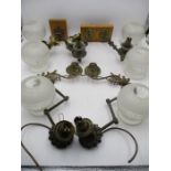 A collection of brass wall lights with glass shades